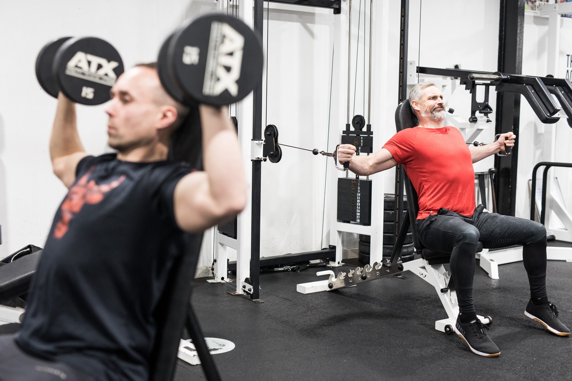 Two people lifting weights in a gym