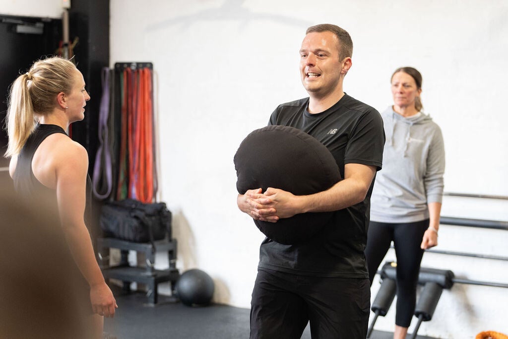 man lifting sandbag in the gym